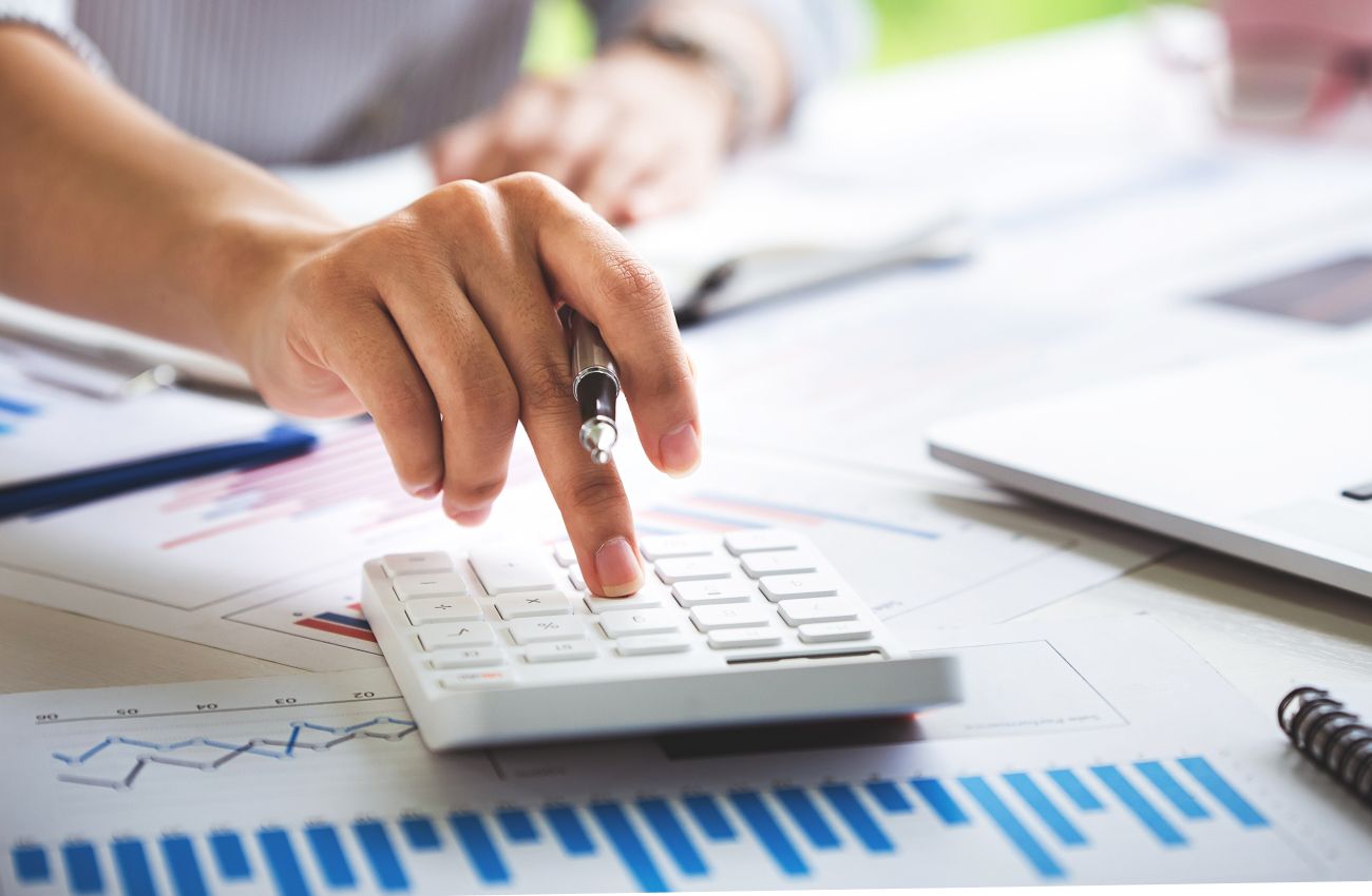 Person rechnet etwas mit einem Taschenrechner aus