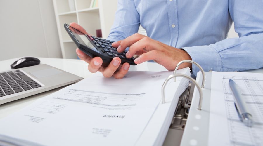 Ein Mann zählt mit einem Taschenrechner.